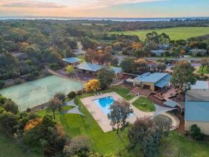 an aerial view of a house with a tennis court and a pool at Woodland Retreat - Phillip Island - Ramada Resort in Cowes