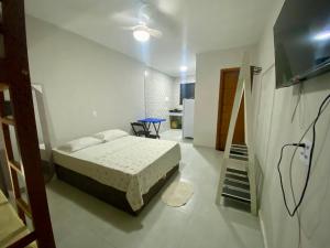 a bedroom with a bed and a staircase in it at Âncora Lofts in Arraial do Cabo