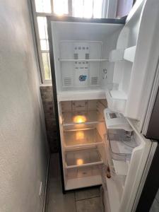 an empty refrigerator with its door open in a kitchen at City suite sosua A in Sosúa
