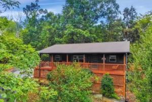 une maison avec une clôture orange et des arbres dans l'établissement Blue Beary Delight Newly renovated Near Everything, à Sevierville