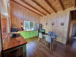 una cucina con pareti in legno, tavolo e sedie di Hospedaje Punto Austral a Los Muermos