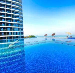 a large swimming pool next to a tall building at Ark Seaview Holiday Inn in Sihanoukville