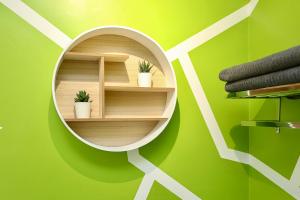 a round mirror on a green wall with plants at Neat City Apartment - Secure Parking - WiFi - Sleeps 4 - No Parties in Belfast +10 photos