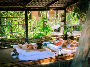 a group of people laying on beds on a porch at Amarit Onsen Homestay 