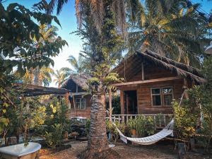 a resort with a hammock in front of a house at Amarit Onsen Homestay 