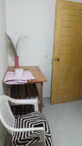 een kamer met een tafel, een stoel en een houten deur bij habitacion doble in Cajamarca