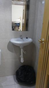 een badkamer met een witte wastafel en een spiegel bij habitacion doble in Cajamarca
