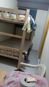 a room with a bunk bed with a table and a shelf at habitacion doble in Cajamarca