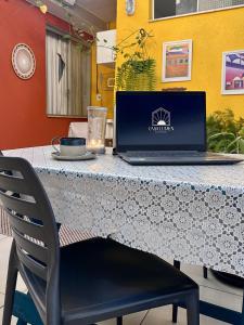 a laptop computer sitting on a table with a chair at GayFriendly Hostel BSB Airport in Brasilia