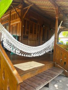 a hammock on the porch of a house at Unzipp Bungalows Gili Air in Gili Air