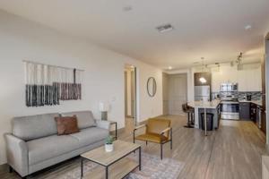 a living room with a couch and a kitchen at Modern 2BR CozySuites on Town Lake waterfront 13 in Tempe