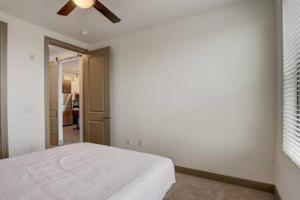 a white bedroom with a bed and a ceiling fan at Modern 2BR CozySuites on Town Lake waterfront 13 in Tempe +31 photos