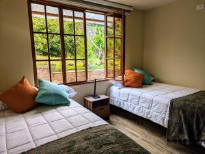 two beds in a room with a window at Casa de Campo Don Panchito 