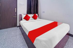 Un dormitorio con una cama con almohadas rojas. en Super OYO Flagship Royal Residency en Nāmakkal