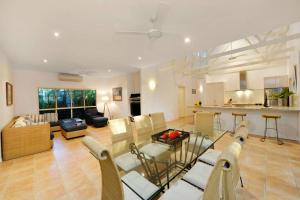 sala de estar amplia con mesa y sillas en Villa Solina, en Port Douglas