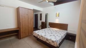 a bedroom with a bed and a wooden cabinet at Eka Studio in Trivandrum