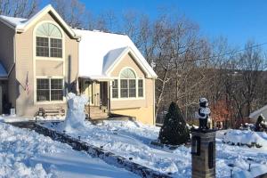 a house covered in snow with a fire hydrant at Luxury getaway in woods, Jacuzzi, Hot Tub, Pool in Bushkill