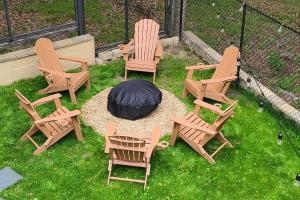 een groep stoelen en een vuurplaats in het gras bij Luxury getaway in vibrant woods. in Bushkill