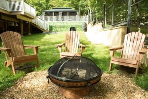 twee stoelen en een vuurplaats in een tuin bij Luxury getaway in vibrant woods. in Bushkill