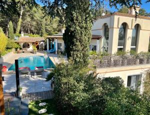 a villa with a swimming pool in front of a house at VILLA NATURISTE JO&SPA ANNA'BELLA Luxury Suites "naturist couples only" in Cap d'Agde