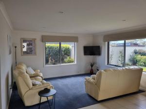 a living room with two couches and a tv at Shore beats working in Port Sorell