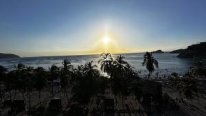 a view of a beach with palm trees and the ocean at Vista increíble Chirama Rodadero in Santa Marta