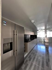 a kitchen with a stainless steel refrigerator and wooden floors at Vista increíble Chirama Rodadero in Santa Marta