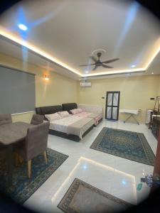 a living room with a couch and a ceiling fan at Makndak Roomstay in Arau