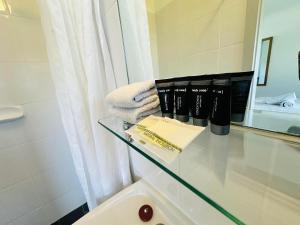 La salle de bains est pourvue d'une table en verre avec un livre. dans l'établissement Beachport Motor Inn, à Beachport 29 autres photos