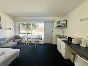 een hotelkamer met een bed, een keuken en een tafel bij Beachport Motor Inn in Beachport