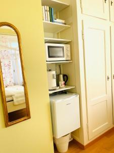 a bathroom with a mirror and a microwave and a refrigerator at Villa28 Self-Check- in in Aarau