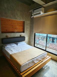 1 dormitorio con 1 cama y 2 ventanas en Ramos Hello Stay Cebu, en Cebú