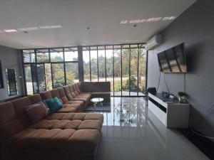 a living room with a couch and a large window at WildernessMountain View in Ban Thung Ta In