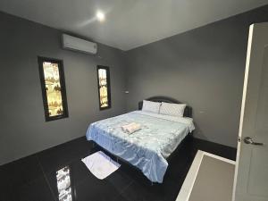 a bedroom with a bed with a blue comforter at WildernessMountain View in Ban Thung Ta In