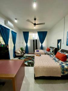 a living room with two beds and blue curtains at Heaven republic Studio in Kangar