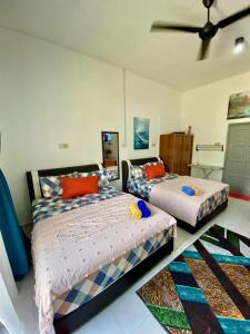 a bedroom with two beds and a ceiling fan at Heaven republic Studio in Kangar