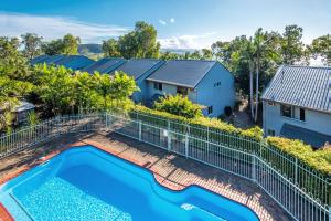 an image of a swimming pool in a yard with a house at Sunset Waters Apartments in Hamilton Island