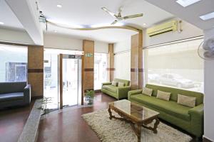 a living room with green couches and a coffee table at Hotel Ambrosia - A Boutique Hotel in New Delhi