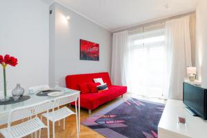 ein Wohnzimmer mit einem roten Sofa und einem roten Stuhl in der Unterkunft Apartament Amaryllis in Krakau