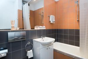 a bathroom with a sink and a toilet and a tub at Apartament Amaryllis in Krakow