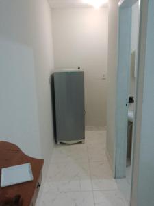 een badkamer met een koelkast in de hoek van een kamer bij Suíte Sunflower 103 in Rio das Ostras
