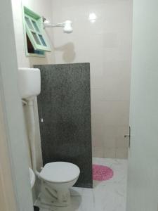 een badkamer met een wit toilet en een douche bij Suíte Sunflower 103 in Rio das Ostras