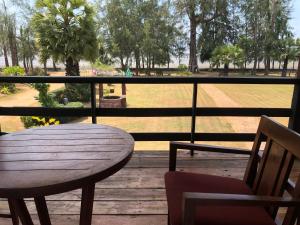 een tafel en stoelen op een veranda met uitzicht op een park bij The Chevalley Beach Resort in Satun