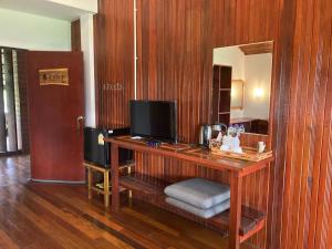 a room with a desk with a television on it at The Chevalley Beach Resort in Satun