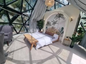 een slaapkamer met een bed in een kamer met ramen bij A'moss Farmstay in Cameron Highlands