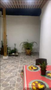una habitación con una mesa con platos y macetas en Habitacion en casa familiar en Barranquilla