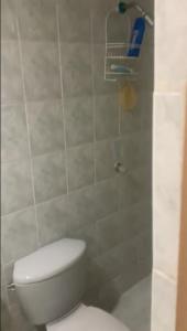 y baño con aseo blanco y ducha. en Habitacion en casa familiar en Barranquilla