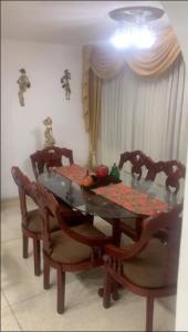 una mesa de comedor con 2 sillas y una mesa con fruta. en Habitacion en casa familiar en Barranquilla