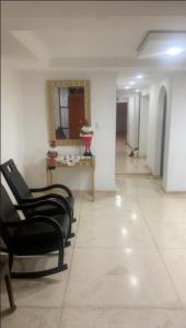 a hallway with chairs and a table in a building at Habitacion en casa familiar in Barranquilla