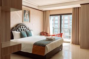 um quarto de hotel com uma cama e uma grande janela em VANHSENG BOUTIQUE VIENTIANE HOTEL em Vientiane